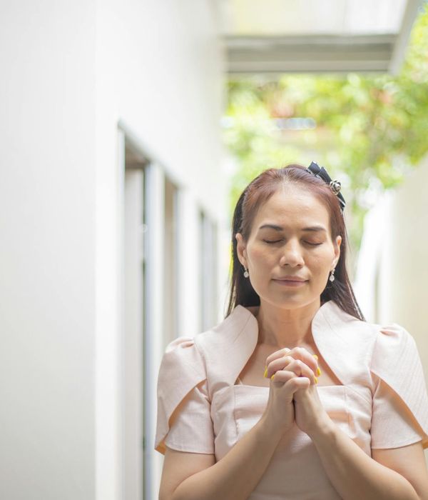 Person meditating outdoors with a serene natural background.